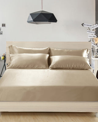 a bed with beige sheets and pillows on it