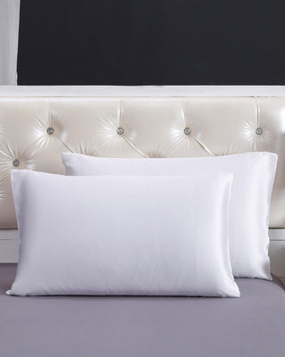 a white pillow sitting on top of a bed