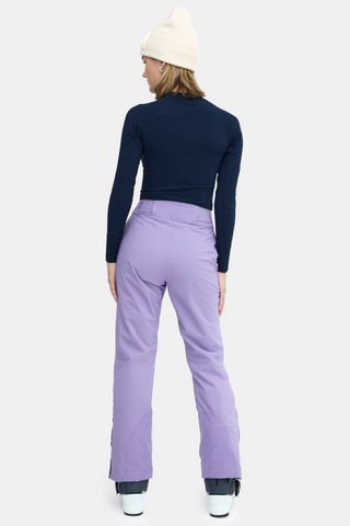 the back view of a woman wearing purple snow pants