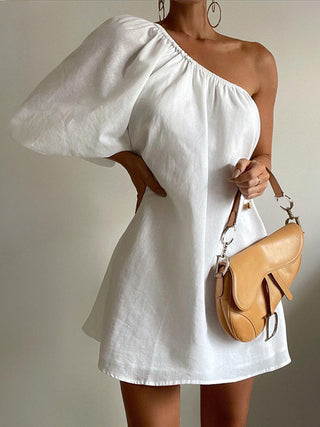 a woman in a white dress holding a purse