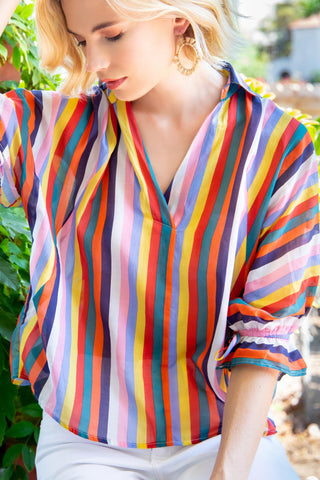 a woman wearing a colorful striped shirt