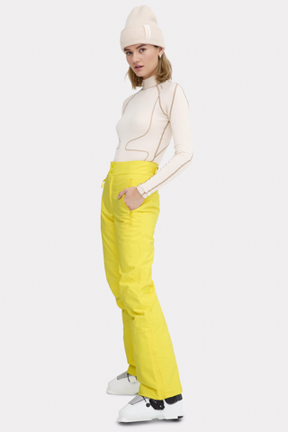 a woman in yellow pants and a white hat