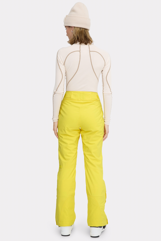 a woman in a white sweater and yellow pants