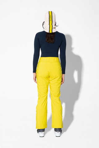 the back view of a woman wearing yellow ski pants