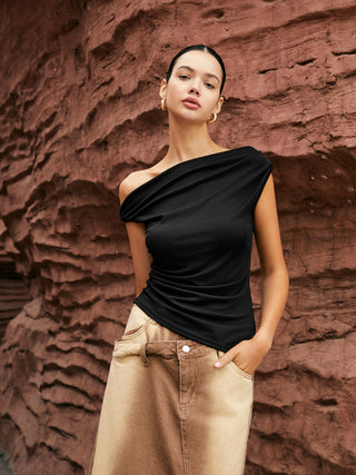 a woman standing in front of a rock wall