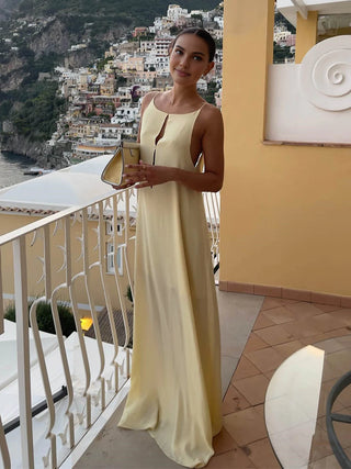 a woman in a yellow dress standing on a balcony