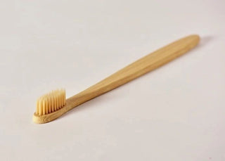 a wooden toothbrush on a white surface