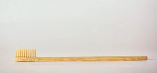 a bamboo toothbrush on a white background