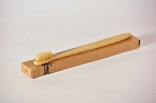 a wooden toothbrush on a white surface