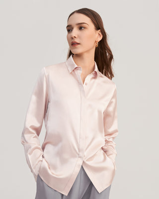 a woman wearing a pink shirt and grey pants