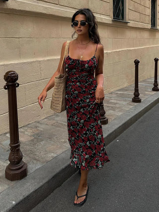 a woman walking down the street wearing a floral dress