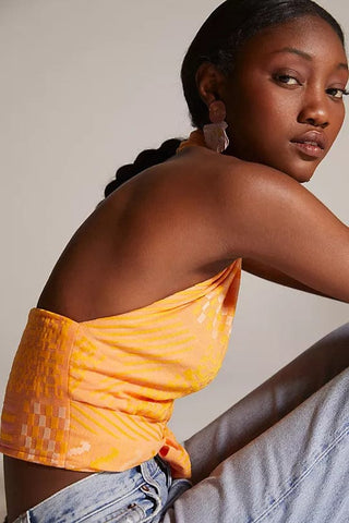 a woman sitting on a chair wearing a yellow top