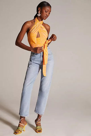 a woman wearing a yellow top and jeans