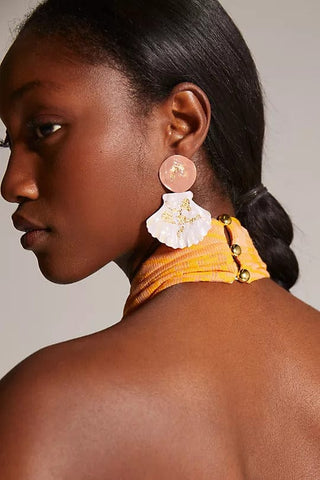 the back of a woman wearing a yellow and white flower earrings