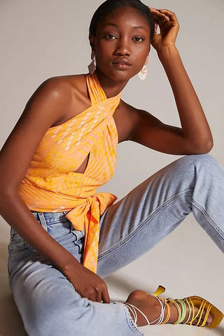 a woman sitting on the floor wearing a yellow top