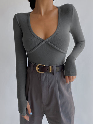 a woman wearing a gray sweater and black pants