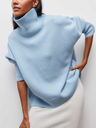 a woman wearing a light blue turtle neck sweater