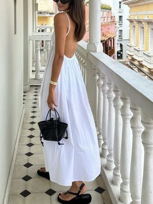 a woman in a white dress standing on a balcony