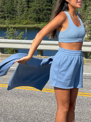 a woman in a blue crop top and shorts