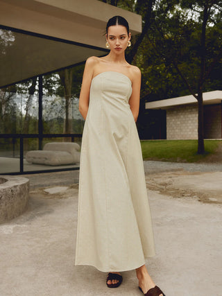 a woman in a white dress standing on a concrete floor