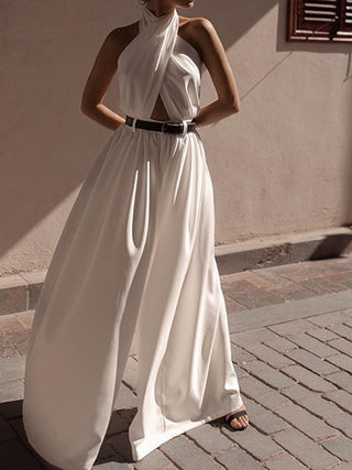 a woman in a white dress standing on the street