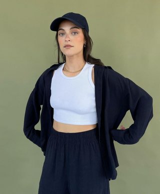 a model in a white crop top and black shorts