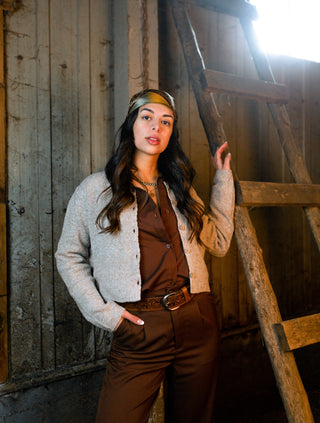 a woman standing in front of a wooden wall