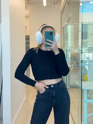 a woman in a black shirt and headphones taking a picture of herself