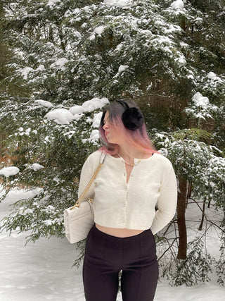 a woman in a white sweater and black pants in the snow