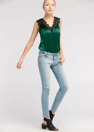 a woman wearing a green top and jeans