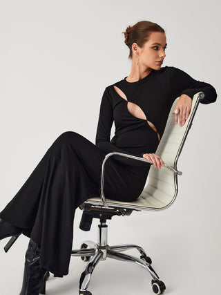 a woman in a black dress sitting on a white chair