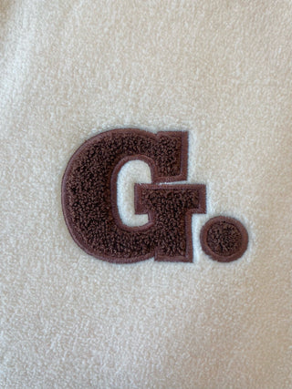 a close up of a towel with the letter g on it