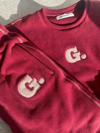 a red sweater with the letter g on it