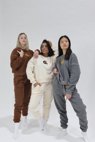 three women in brown and white onesuits