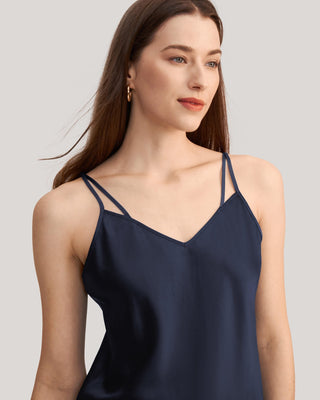 a woman wearing a dark blue top with spaghetti straps