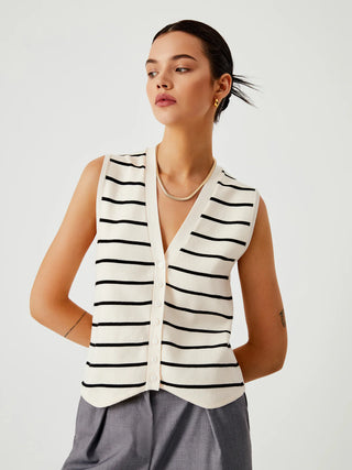 a woman wearing a white and black striped vest