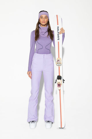 a woman in ski gear holding a snowboard