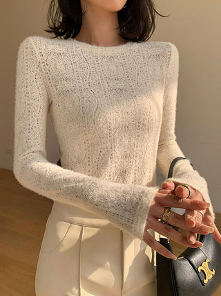 a woman wearing a white sweater and white pants