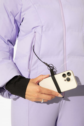 a woman in a purple jacket holding a cell phone