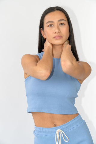 a woman wearing a blue crop top and shorts