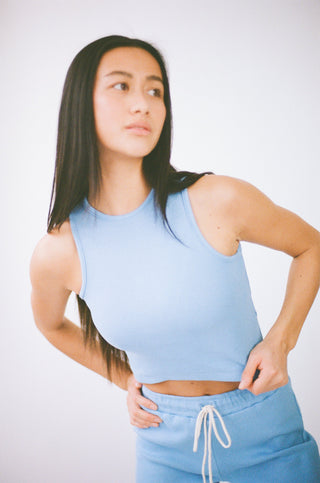 a woman in a blue tank top and shorts