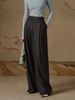 a woman in a blue sweater and black wide pants