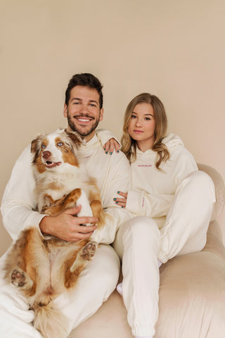 a man and woman sitting on a couch with a dog