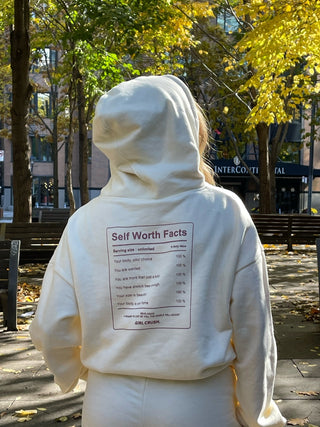 a person in a white hoodie standing on a sidewalk