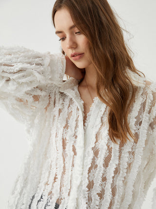 a woman wearing a white lace jacket