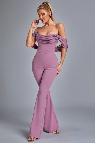 a woman wearing a purple off the shoulder jumpsuit