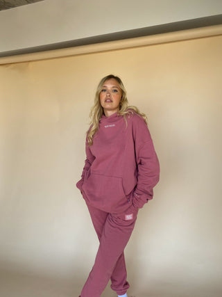 a woman in a pink sweatshirt and sweat pants