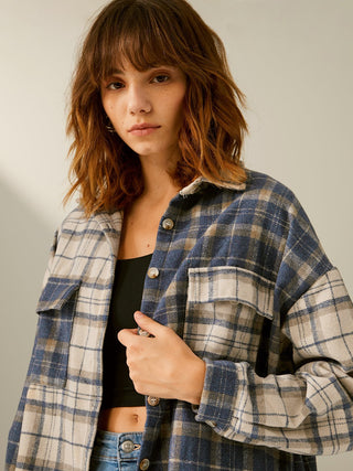 a woman wearing a blue and white plaid jacket