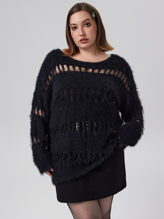 a woman wearing a black sweater with fringes