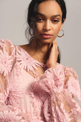 a woman wearing a pink dress with flowers on it